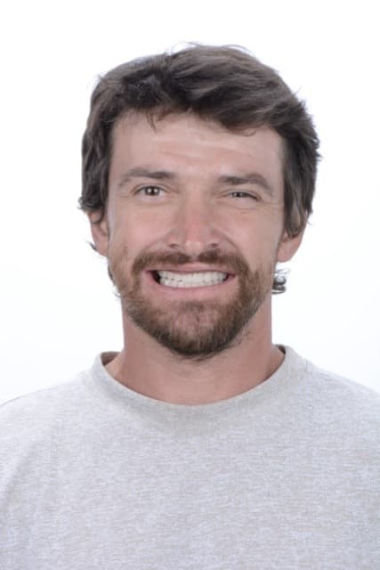Male patient smiling after full-arch dental implant restoration